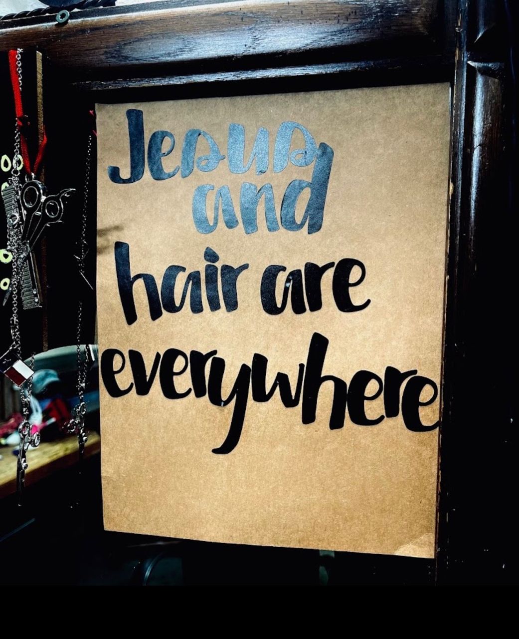 Hand-lettered sign reading Jesus and hair are everywhere